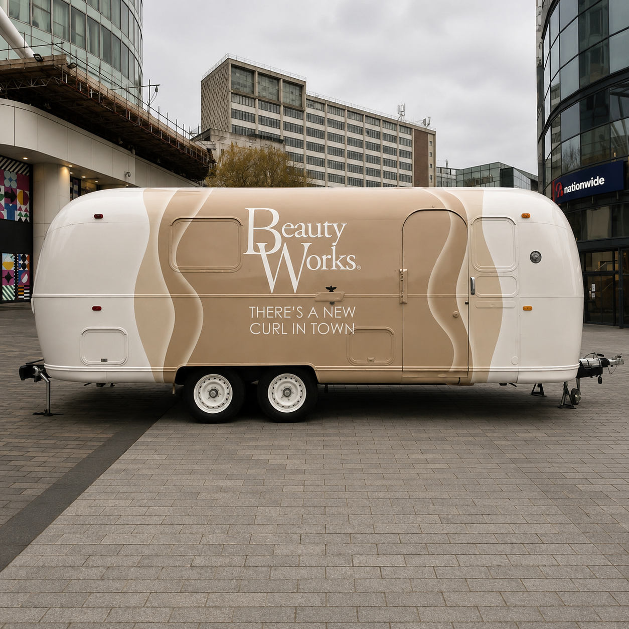 Cream beauty salon trailer with beige wave graphics and Beauty Works branding.